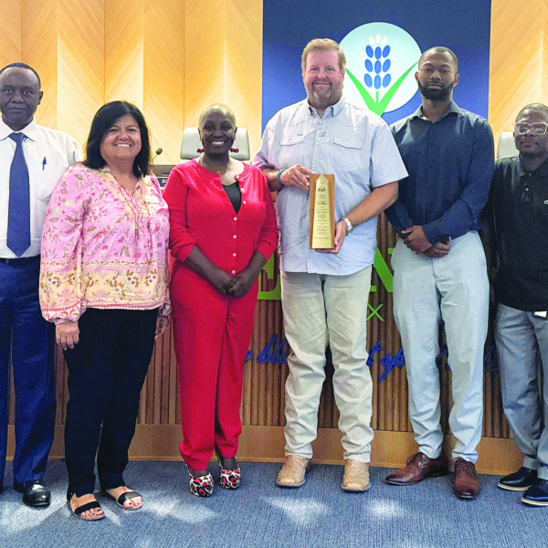 Katrinia Roberson (in red, left of center) received an award (held by David Espedal) for financial excellence. Courtesy Photo/City of Ennis