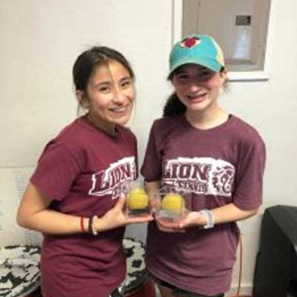 JV tennis players making racket at home tournament