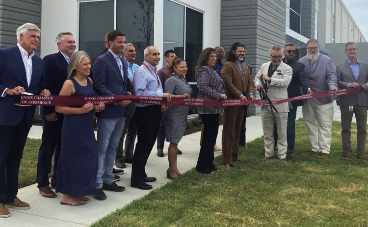 Courtesy Photo/Joe Newman Amir Loloi (with scissors) and Mayor Lynda Isbell (to his left) and a host of dignitaries at the grand opening of Loloi Rugs.