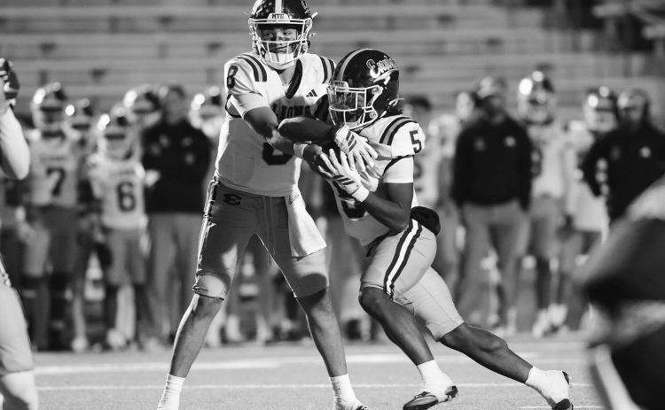 QB Chris Martinez hands the ball to Wenderius Jones in a game last year. Chris McGathey Photo