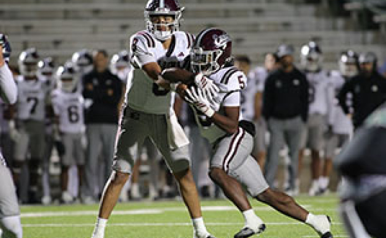 QB Chris Martinez hands the ball to Wenderius Jones in a game last year. Chris McGathey Photo