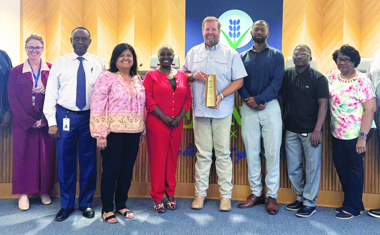 Katrinia Roberson (in red, left of center) received an award (held by David Espedal) for financial excellence. Courtesy Photo/City of Ennis